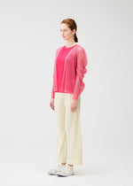 A woman with braided hair in profile stands against a white background, wearing a bright pink mesh cardigan, a pink top, OPAQUE BOTTOMS by PLEATS PLEASE ISSEY MIYAKE, and white sneakers.