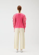 A person with braided hair faces away, wearing a bright pink matte-texture mesh top, white shoes, and cream OPAQUE BOTTOMS by PLEATS PLEASE ISSEY MIYAKE against a plain white background.