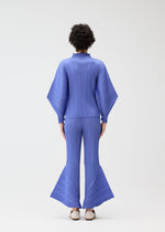 A person with curly hair faces away, wearing the SKYLINE pleated bright blue top and matching city-inspired pants by PLEATS PLEASE ISSEY MIYAKE, against a plain white background.