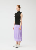 A woman with light skin and tied-back hair stands in profile against a white background, wearing PLEATS PLEASE ISSEY MIYAKE's OPAQUE BOTTOMS—a pleated lavender midi skirt—paired with a sleeveless black top and white sneakers.