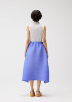 A person with short, curly dark hair faces away in the BOUNCY BASKET sleeveless white pleated top and blue basket-silhouette skirt by PLEATS PLEASE ISSEY MIYAKE, styled with tan platform sandals against a plain white background.
