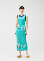 A woman with short black hair and a relaxed look poses against a white backdrop wearing the sleeveless I SPY! pleated dress by PLEATS PLEASE ISSEY MIYAKE, featuring teal with white wavy patterns and a blue neckline, paired with beige platform sandals.