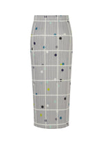 The CROSSING DOTS skirt by PLEATS PLEASE ISSEY MIYAKE is a high-waisted, knee-length design with a gray base, white grid lines, and multicolored dots.