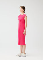 A person stands in profile wearing the knee-length, sleeveless MONTHLY COLORS : JUNE dress by PLEATS PLEASE ISSEY MIYAKE with white sneakers, set against a plain white background.