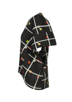 CROSSING DOTS by PLEATS PLEASE ISSEY MIYAKE is a sculptural round-neck top with pleated fabric, showcasing a white grid and colorful dots in red, yellow, and green, photographed on a white background.