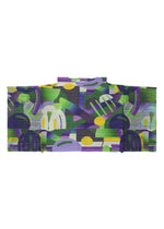 PLAYGROUND by PLEATS PLEASE ISSEY MIYAKE features abstract geometric patterns in green, purple, yellow, and blue tones, creating a vibrant and dynamic look inspired by modern sleeveless tunics.