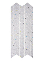 The CROSSING DOTS SCARF by PLEATS PLEASE ISSEY MIYAKE features a white background with a grey herringbone pattern and colorful dots in yellow, blue, purple, and black—evoking a bold city print or abstract scarf design.
