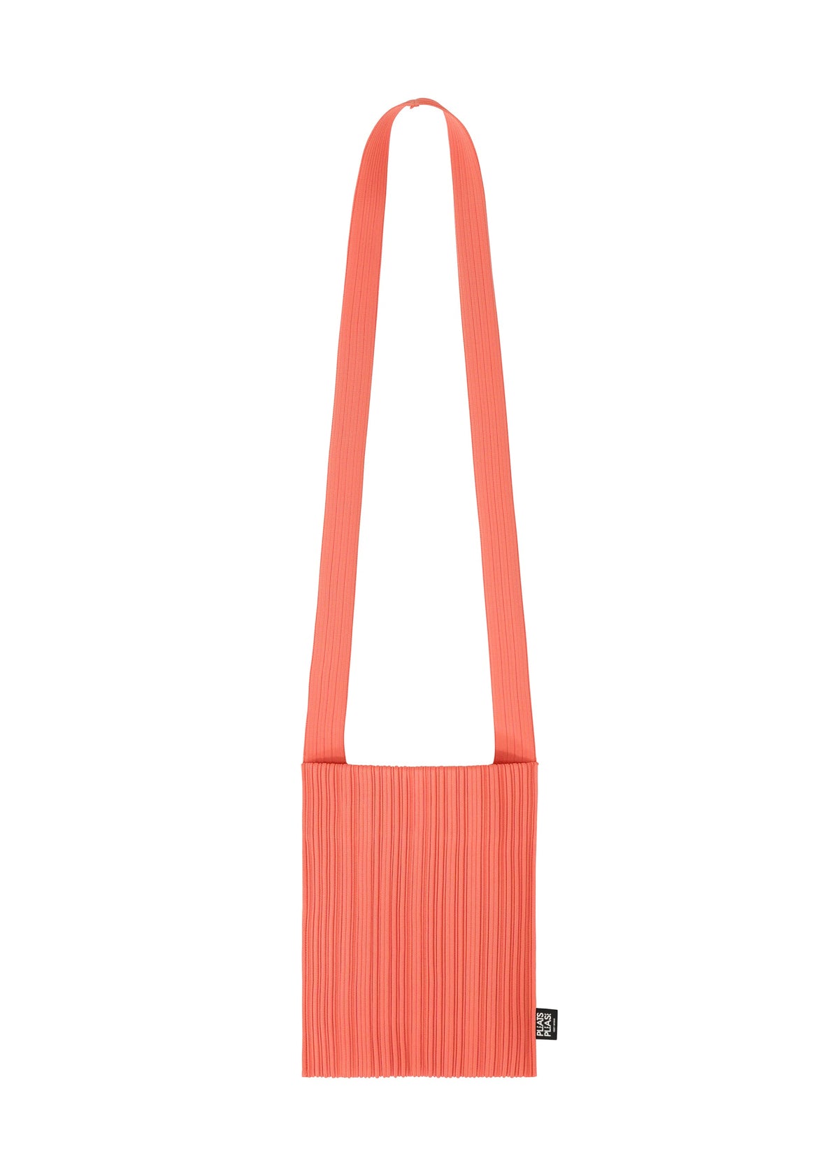 The CREPE KNIT BAG by PLEATS PLEASE ISSEY MIYAKE is a coral pink pleated bag with a wide strap and a small black tag on the side, shown against a plain white background. view 2 of 6