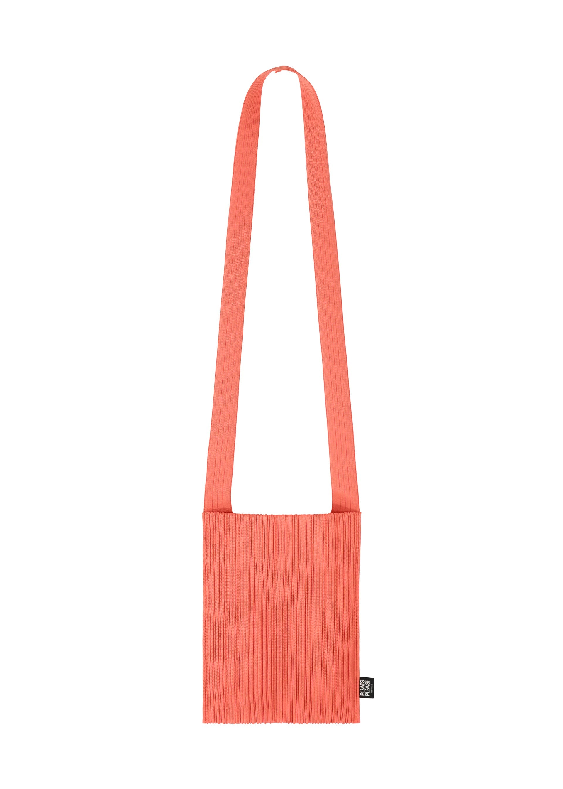 Zoomed view The CREPE KNIT BAG by PLEATS PLEASE ISSEY MIYAKE is a coral pink pleated bag with a wide strap and a small black tag on the side, shown against a plain white background. - LIGHT PINK （no.20）