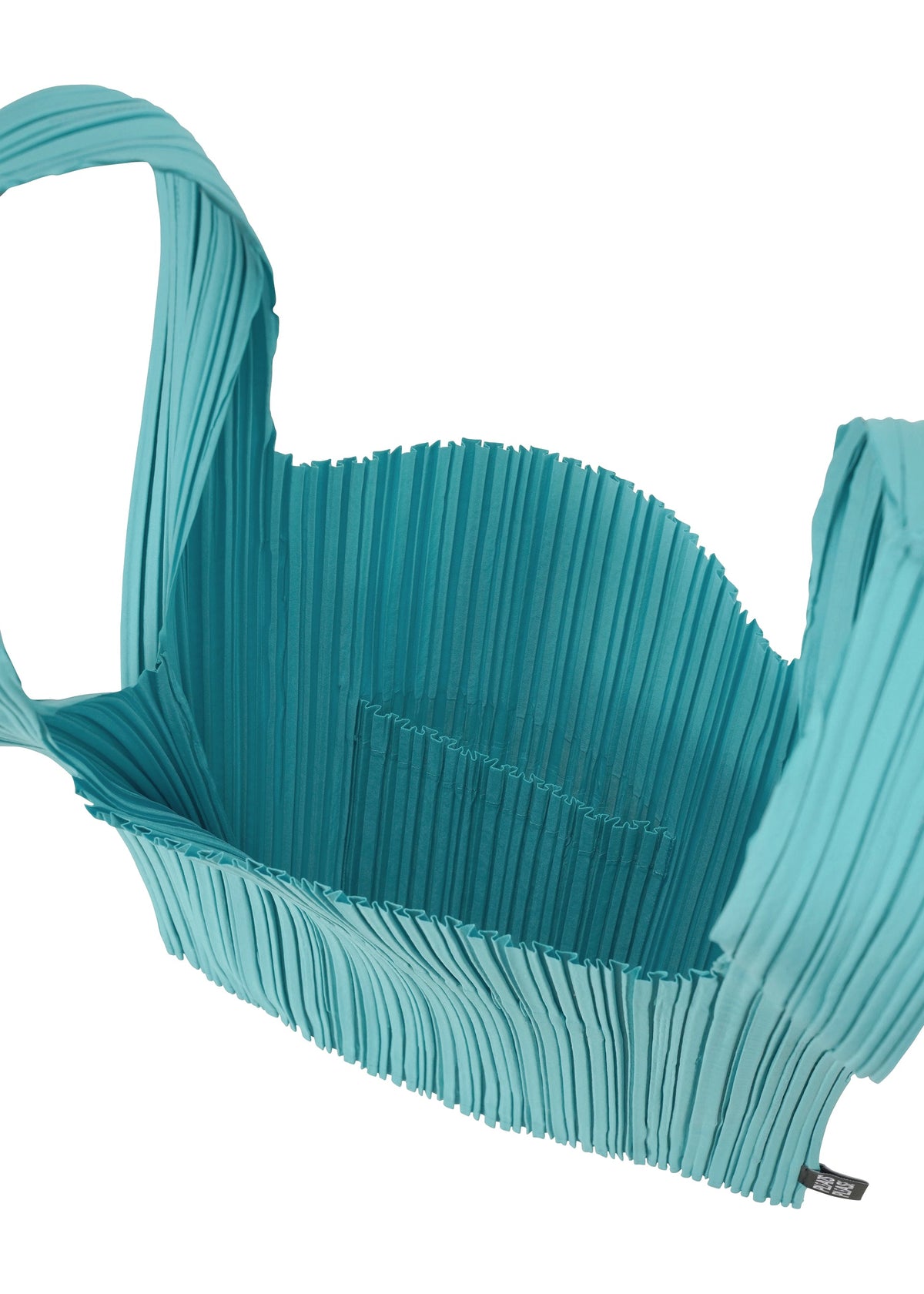 The PLEATS SHOPPING TOTE by PLEATS PLEASE ISSEY MIYAKE is a turquoise, pleated bag featuring a wide strap, open top, spacious textured interior, and a small inner pocket. view 4 of 4