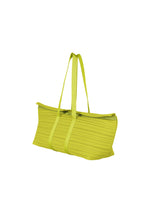 The PLEATS BOSTON BAG by PLEATS PLEASE ISSEY MIYAKE is an oblong, lime green bag with a ribbed texture, horizontal pleats, two long handles, and a zipper closure, displayed on a plain white background.