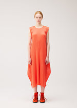A person stands against a plain background wearing the MONTHLY COLORS : SEPTEMBER sleeveless orange pleated dress with an asymmetrical hem from PLEATS PLEASE ISSEY MIYAKE, paired with matching orange boots.