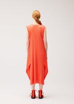 A person with long, braided hair wears the MONTHLY COLORS : SEPTEMBER sleeveless bright orange pleated midi dress by PLEATS PLEASE ISSEY MIYAKE—styled with a round neck and flared silhouette—and matching orange sandals, standing against a plain light background, facing away from the camera.