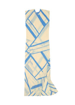 The FOLD LINE dress by PLEATS PLEASE ISSEY MIYAKE features a sleeveless cream silhouette adorned with a blue geometric pattern and accented by a subtle ruffle detail near the hem, presented in a minimalist style and displayed flat against a white background.