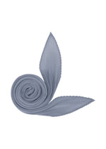 The MONTHLY SCARF AUGUST by PLEATS PLEASE ISSEY MIYAKE features a pleated, diamond-shaped design in light blue, artfully coiled with two pointed ends resembling a stylized leaf or floral motif on a clean white background—an ideal accessory to infuse refreshing color into your midsummer wardrobe. - LIGHT BLUE （no.70）