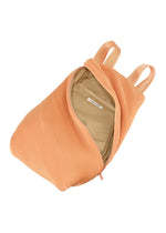 The BIAS PLEATS BACKPACK by PLEATS PLEASE ISSEY MIYAKE features peach-colored ribbed fabric, two straps, an open zipper that reveals a beige interior, and an inner pocket.