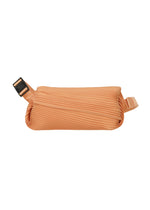The BIAS PLEATS WAIST BAG by PLEATS PLEASE ISSEY MIYAKE is a small, peach rectangular bag with textured diagonal pleats and an adjustable strap with a black buckle—adding a stylish touch to any outfit. - PALE ORANGE （no.30）