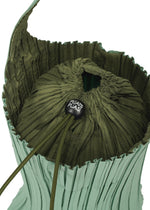 A close-up of the PLEATS SWAN BAG by PLEATS PLEASE ISSEY MIYAKE shows its elegant green exterior adorned with graceful vertical pleats and a partially open top. The drawstring closure features a black cord lock labeled “PLEATS PLEASE.”.