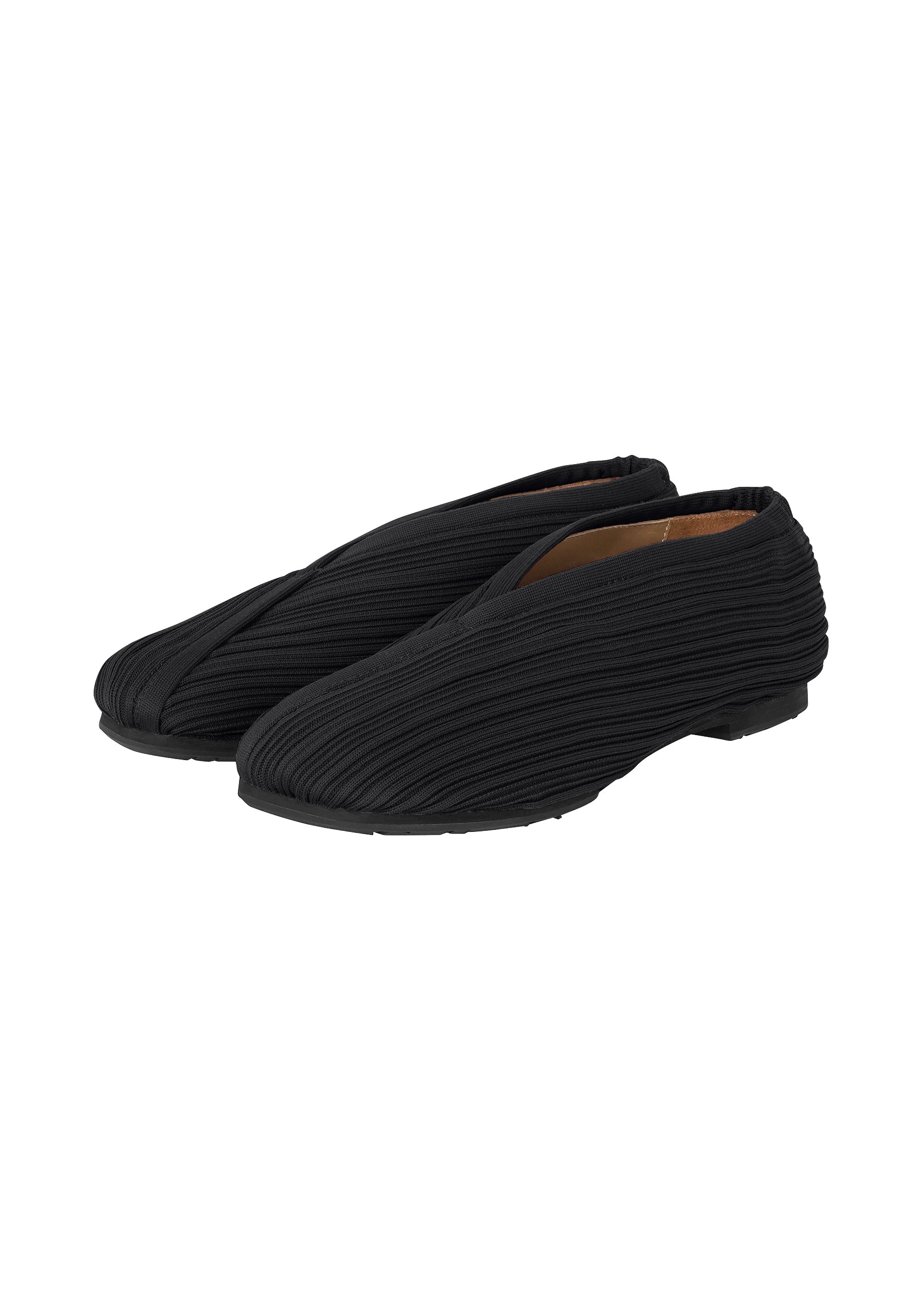 Zoomed view A pair of KNIT BALLET SHOES by PLEATS PLEASE ISSEY MIYAKE in black, featuring ribbed knit fabric, flat soles, and a subtle pleated design, displayed at an angle on a white background. - BLACK （no.15）