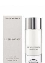 A bottle of ISSEY MIYAKE PARFUMS LE SEL EAU DE TOILETTE 150mL, a refined salt-inspired eau de toilette, is displayed beside its coordinating beige box, both adorned with understated silver text and minimalist design.
